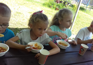dzieci jedzą zupę pomidorową